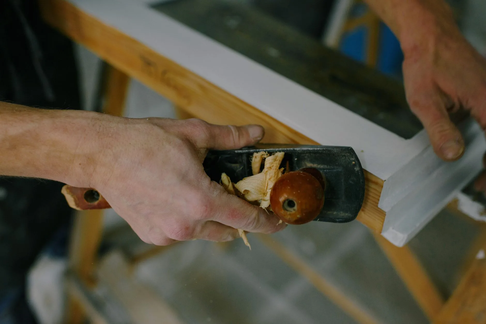 Carpenter's hands at work installing a window frame, representing the hands-on trade Double Y Framing is built on